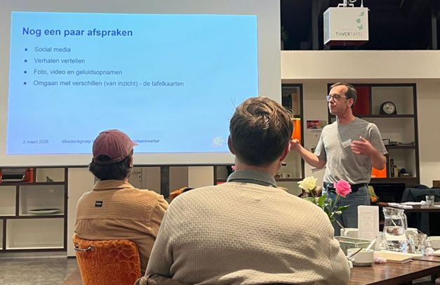 Bewoners in De Blinkert luisteren naar een presentatie over de afspraken van de meedenkgroep