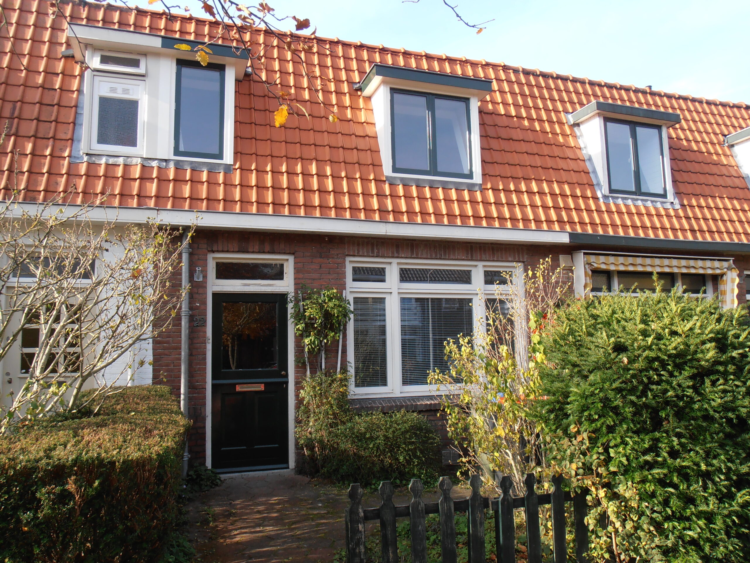 Vooroorlogse rijwoning in het Ramplaankwartier met bakstenen gevel, pannendak en dakkapellen.